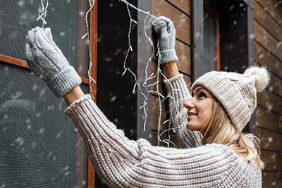 Woman Hanging Lights - Guide to Solar Powered Chistmas Lights